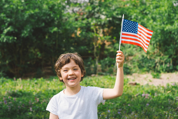 Χαρούμενο πατριωτικό αγοράκι με αμερικανική σημαία. Οι ΗΠΑ γιορτάζουν την 4η Ιουλίου. Χαρούμενη ημέρα ανεξαρτησίας - Φωτογραφία, εικόνα