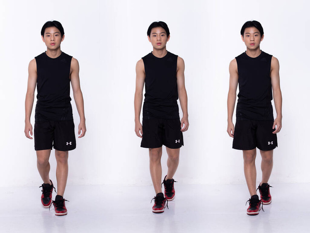 Teljes hosszúságú ázsiai tinédzser fiú, balról jobbra sétál előre, fekete inget visel rövid nadrágban. Sport férfi állni és megmutatni izom sportoló fehér háttér elszigetelt - Fotó, kép