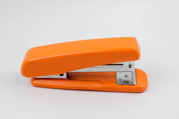 orange big stapler on white background in studio - Photo, Image