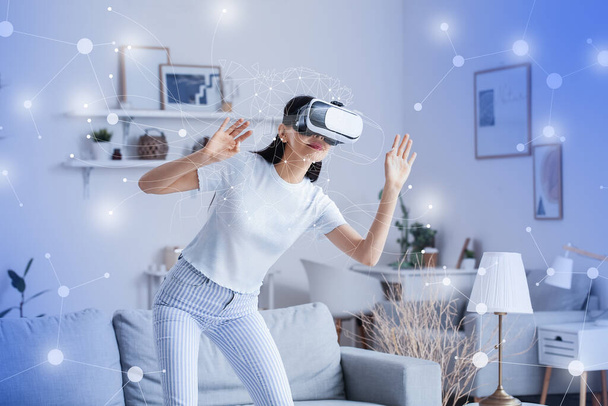 Γυναίκα με γυαλιά VR χρησιμοποιώντας εφαρμογή smart home automation στο δωμάτιο - Φωτογραφία, εικόνα