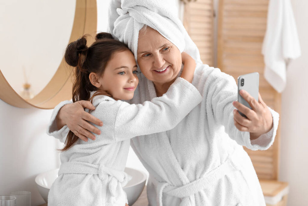Little girl with her grandma taking selfie in bathroom - Photo, Image