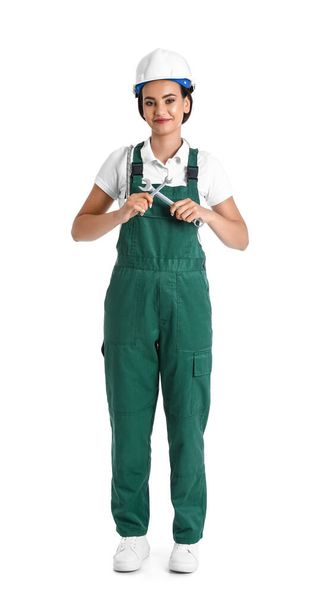 Female plumber with wrenches on white background - Foto, afbeelding