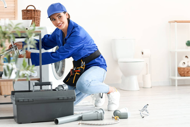 Kobieta hydraulik naprawianie umywalka w łazience - Zdjęcie, obraz