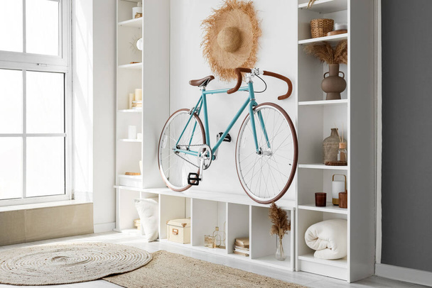 Інтер'єр сучасної вітальні з велосипедом і білим стелажем
 - Фото, зображення
