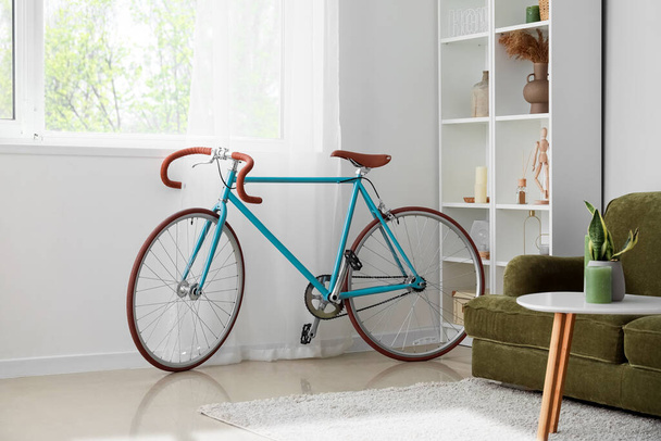 Modern bicycle near window in light living room - Photo, Image