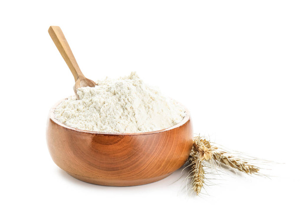 Bowl with flour, scoop and wheat ears on white background - Photo, Image