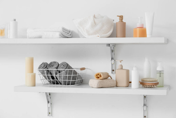 Shelves with bath accessories hanging on light wall - Photo, Image