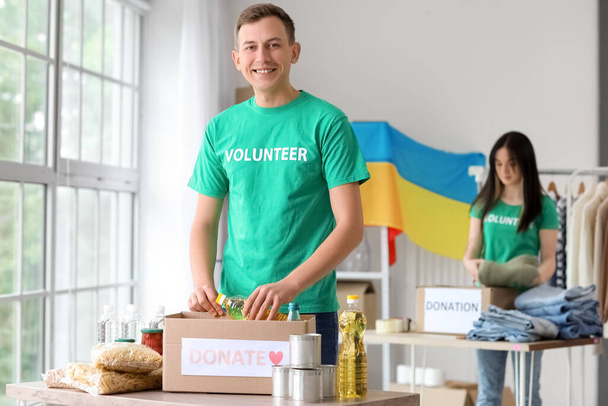 Voluntario polaco poniendo botella de aceite de girasol en la caja de donación para Ucrania en el centro - Foto, imagen