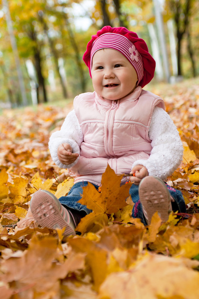 Smiley girl on yellow leaves - Φωτογραφία, εικόνα