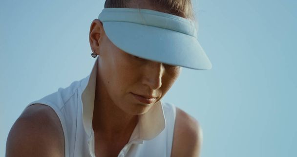 Woman wear sport clothes visor cap uniform on club course. Portrait of attractive golfer enjoy summer holiday. Focused thoughtful golf player looking down on fairway. Luxury activity leisure concept. - Foto, imagen