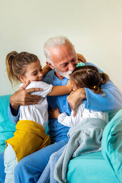 Little girls visiting grandfather in hospital, who is recovering from coronavirus. Healthcare, virus, family support concept - Photo, image