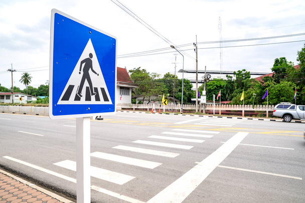 Lege mensen en passagiers op oversteekplaats of zebra bord op de weg in landelijke gebieden in de provincie Uthai Thani, Thailand, met de lokale bevolking bouw en milieu. - Foto, afbeelding