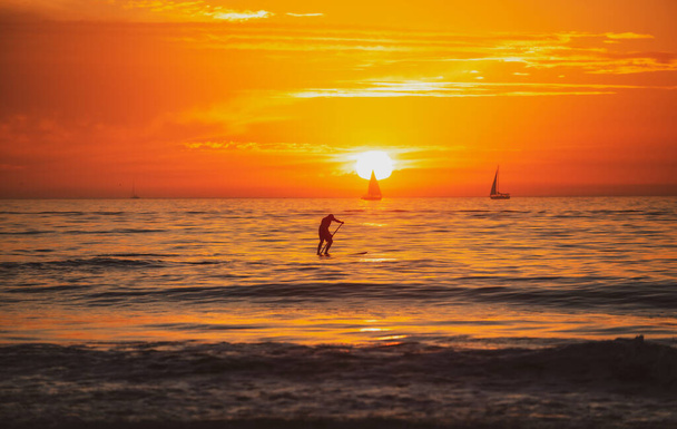 Paddle boarding. People on Paddle boat on sea at sunset - Fotografie, Obrázek