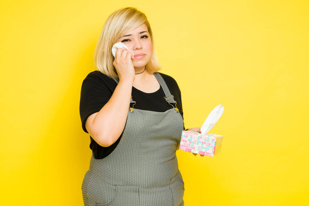 Fat young woman crying with a box of tissues after getting heartbroken - Photo, Image
