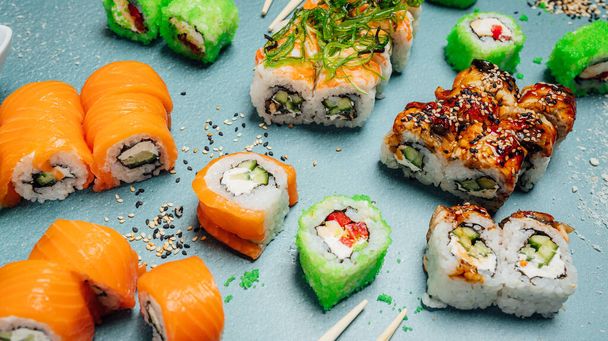 Rollos de sushi frescos y sabrosos en la mesa, menú de barra de sushi, tabl de comida asiática - Foto, Imagen