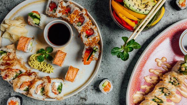Свежие и вкусные суши-роллы на столе, меню суши-бара, азиатский пищевой стол - Фото, изображение