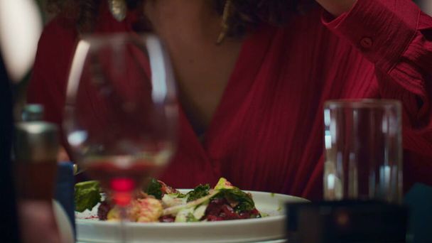 Wunderschöne Frau beim Essen leckeres Abendessen im feinen Restaurant. Porträt eines afrikanisch-amerikanischen Mädchens, das köstliche kulinarische Speisen im Loft-Café genießt. Lächelnde Dame beim Date. Speisekonzept. - Foto, Bild