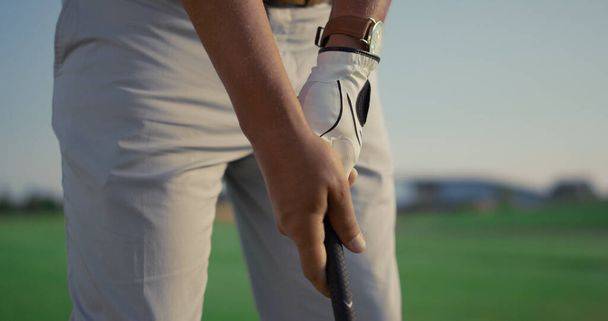 Pelaaja pitää golf putter klubi golfpeli. Mies harrastaa urheilua lähikuvassa. Professional golfaaja käsissä koulutusta harjoitellaan toimintaa taitoja ulkona auringonlaskun väylällä. Resort, käsite. - Valokuva, kuva