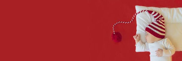 Bébé dort dans un chapeau de Père Noël. Concentration sélective. Les gens. Joyeux Noël et bonne année, Fêtes fond de carte de voeux. Concentration sélective. - Photo, image