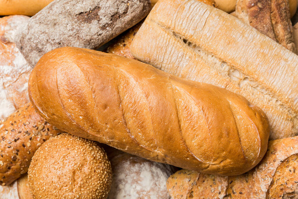 Homemade natural breads. Different kinds of fresh bread as background, top view with copy space. - Photo, Image