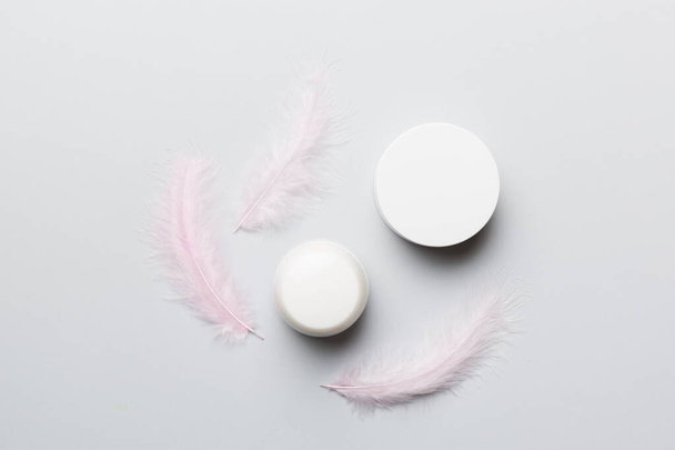 Spa cosmetic product, cream jar, branding mock up, top view with feathers background. Flat lay. - Фото, изображение
