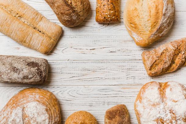 Panes naturales caseros. Diferentes tipos de pan fresco como fondo, vista superior con espacio de copia. - Foto, Imagen