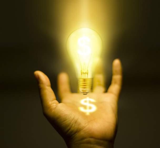 Light bulb geld in hand op donkere achtergrond - bedrijfsconcept - Foto, afbeelding