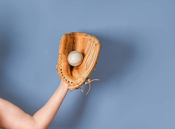 Hand in a leather baseball glove caught a ball - Фото, изображение