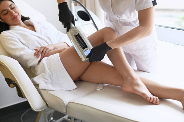 Beautiful woman enjoys buttocks massage with  machine for anti-cellulite and body correction - Zdjęcie, obraz