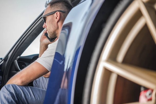 Muž běloch Podnikatel ve svých 40 s telefonem konverzace, zatímco sedí ve svém luxusním sportovním autě. - Fotografie, Obrázek