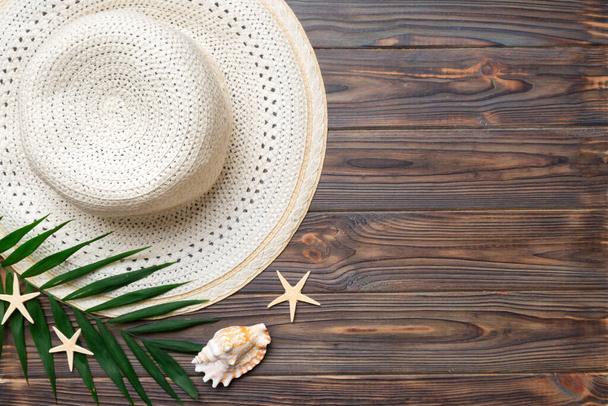 Summer holidays. Summer concept with straw hat and tropical leaf. Flat lay, top view, copy space. - Fotó, kép