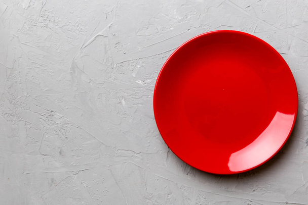 Top view of empty red plate on cement background. Empty space for your design. - Foto, imagen