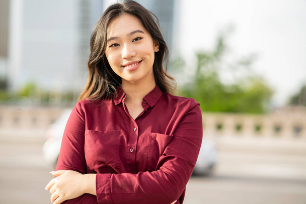 La moderna empresaria cruzó las manos por fuera. bonita joven asiática mujer sonriendo. concepto de negocio - Foto, imagen