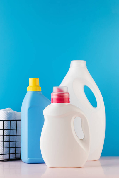Different bottles with washing gel on a blue background. The concept of laundry, washing, household chemicals. Place for a logo. - Fotografie, Obrázek