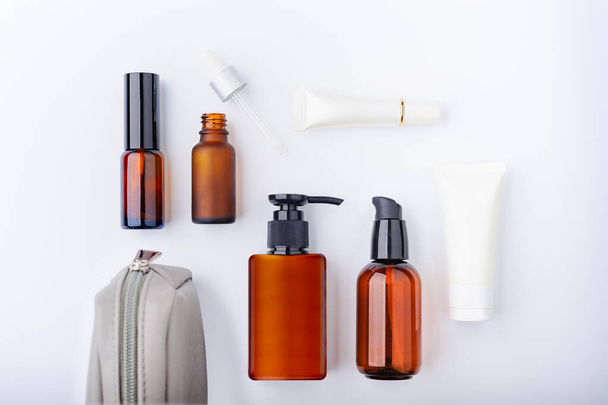 Amber cosmetic bottle, dropper and white cream tube. Hotel amenity kit. Blank label for branding mock-up - Photo, Image