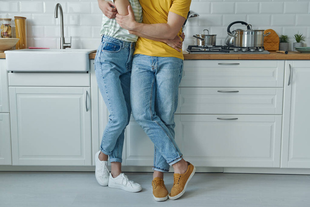 Close-up of couple embracing while standing at the kitchen - 写真・画像