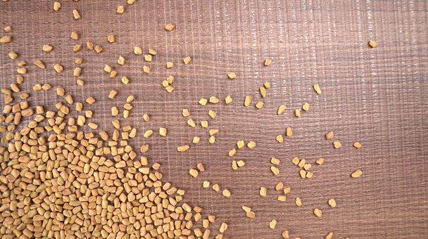 Organic fenugreek seeds on table, ingredient of Indian cuisine, closeup shot  - Foto, Imagen