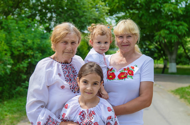 Семейное фото украинки в вышитых рубашках. Выборочный фокус. Природа. - Фото, изображение