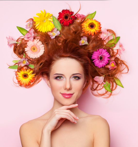 Çiçekli pembe bir arka plan üzerinde güzel kızıl saçlı kız - Fotoğraf, Görsel