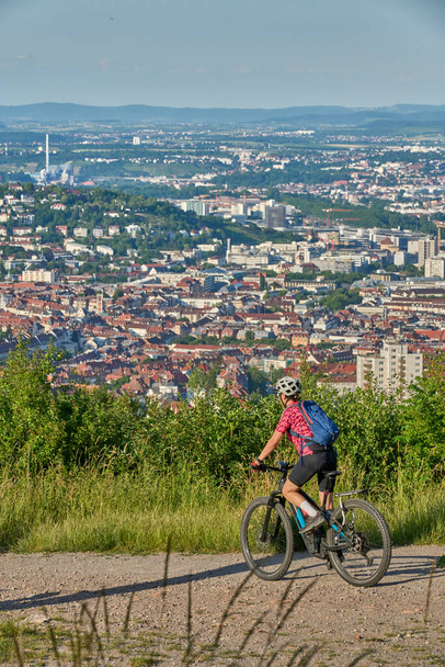 Mulher sênior ativa agradável com bicicleta de montanha elétrica em um passeio nas colinas acima da cidade de Stuttgart, Baden-Wuerttemberg, Alemanha - Foto, Imagem