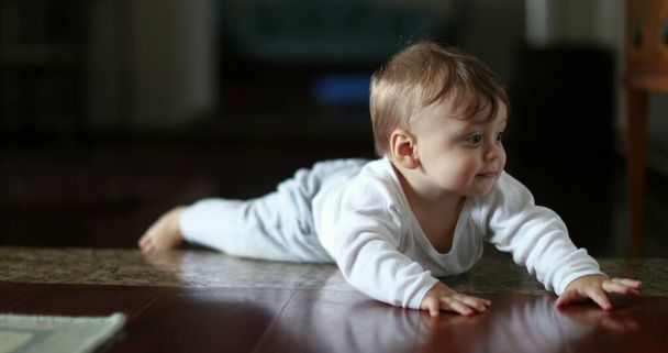 Cute baby learning to climb down home step, infant development - Photo, image