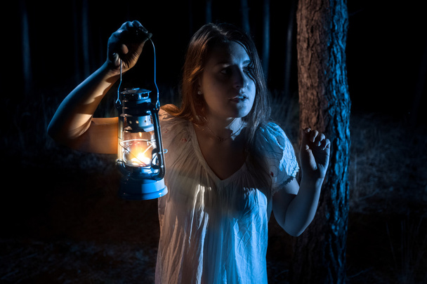 Portret van bang vrouw verloren in het bos verlichting van de weg met - Foto, afbeelding