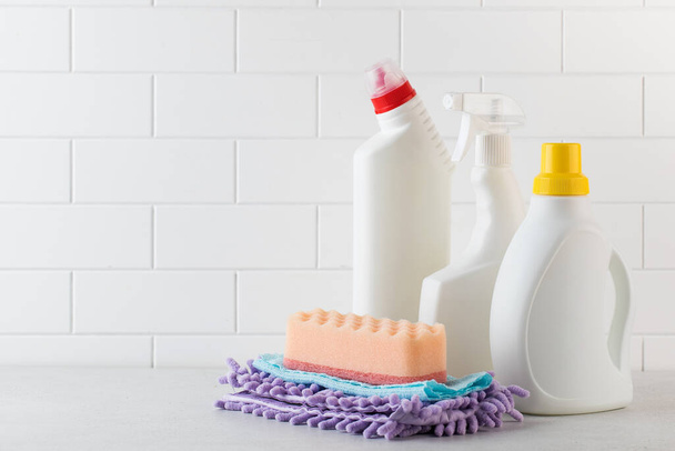  A set of different detergents, sponges and rags on a light background. The concept of cleaning, hardware store, cleaning service. - Φωτογραφία, εικόνα