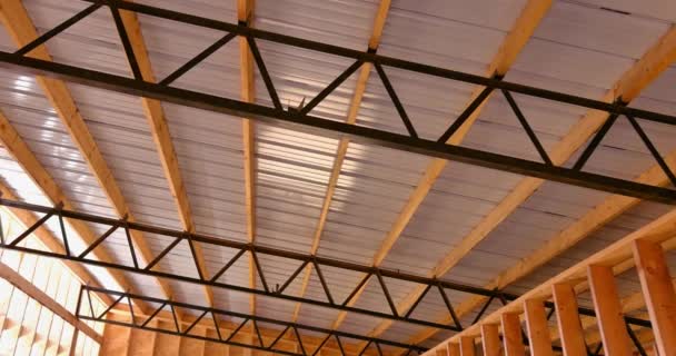 Wnętrze placu budowy nowego dachu metalowego i drewnianej ramy magazynu - Materiał filmowy, wideo
