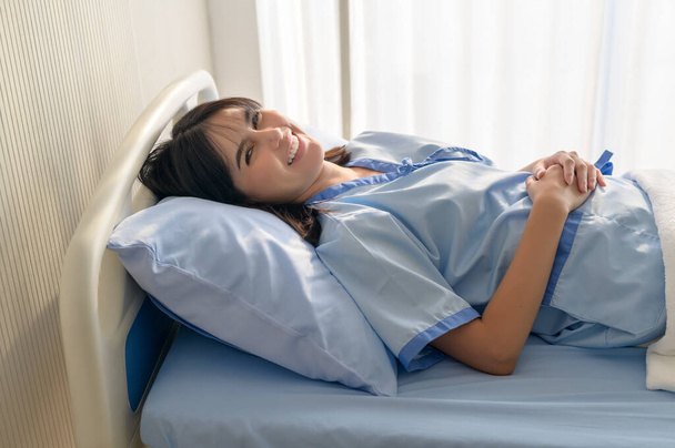 Toiveikas ja onnellinen nuori potilas nainen sairaalassa, terveydenhuollossa ja lääketieteellisessä konseptissa - Valokuva, kuva