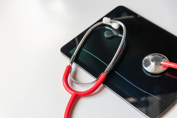 Rotes Stethoskop auf schwarzem Tablet-Gerät zeigt Krankenakten und digitale Patientenakten über Cloud-Datensicherheit für digitale Ärzte und digitale Genesungsdiagnostik mit moderner Ausrüstung und Technologie - Foto, Bild