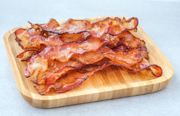 Bandes de bacon frites sur la plaque de bois - Photo, image