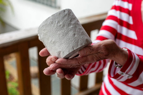 close-up of older woman holding a role toilet paper in her hands - Foto, Imagen