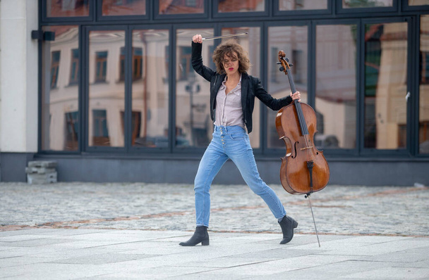 Una música femenina con un violonchelo en la calle - Foto, Imagen