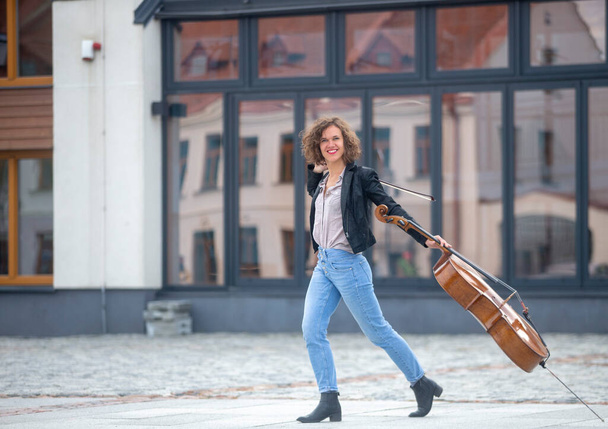 Una música femenina con un violonchelo en la calle - Foto, Imagen